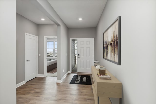 foyer with baseboards, wood finished floors, and recessed lighting