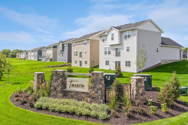 community sign featuring a residential view and a lawn