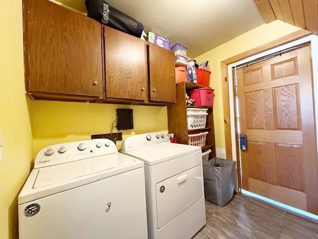 clothes washing area featuring cabinet space and washer and clothes dryer