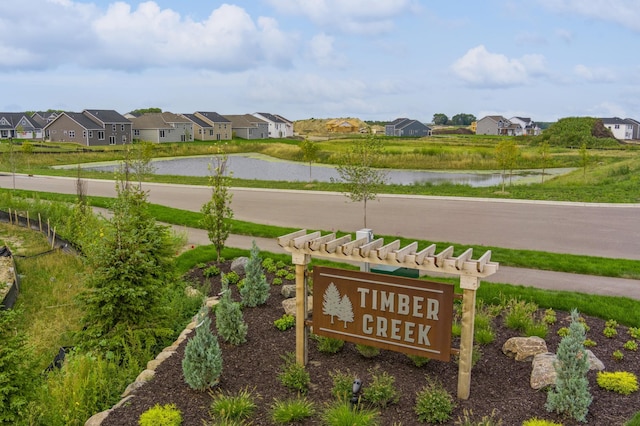 community sign with a water view and a residential view