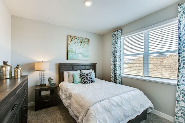 bedroom featuring dark colored carpet and baseboards