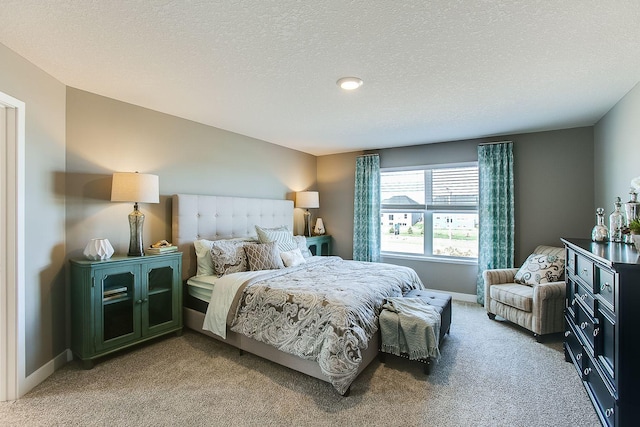 bedroom with carpet flooring, a textured ceiling, and baseboards