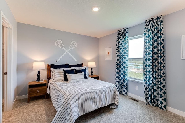 carpeted bedroom featuring visible vents and baseboards