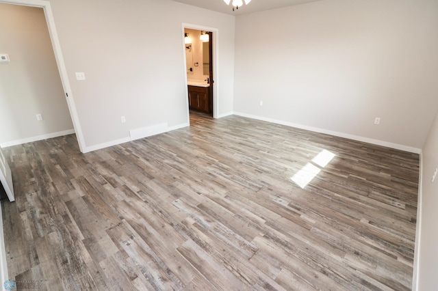 empty room featuring baseboards and wood finished floors