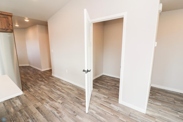 spare room featuring light wood-style floors, baseboards, and recessed lighting