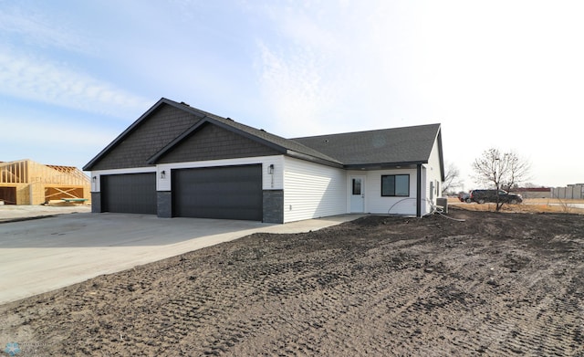 ranch-style house with driveway, an attached garage, and cooling unit