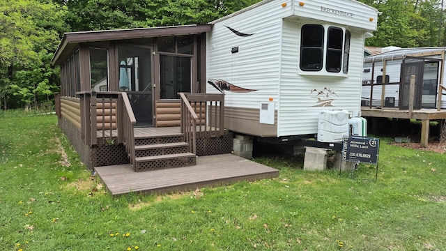 13087 Twilight Rd # 15, Onamia, MN 56359 - rear view of property featuring a sunroom, a wooden deck, and a lawn