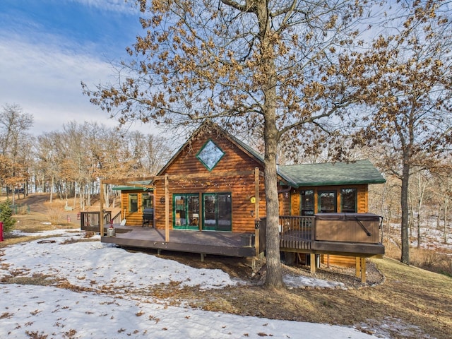 view of front facade featuring faux log siding and a wooden deck