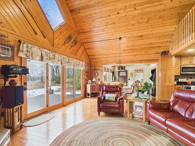 living room featuring a skylight, light wood finished floors, wooden walls, wooden ceiling, and high vaulted ceiling