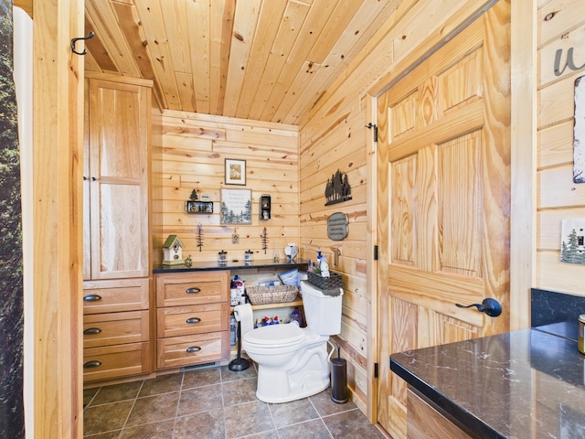 bathroom with wooden ceiling, wooden walls, toilet, and tile patterned floors