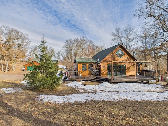 snow covered rear of property with a deck