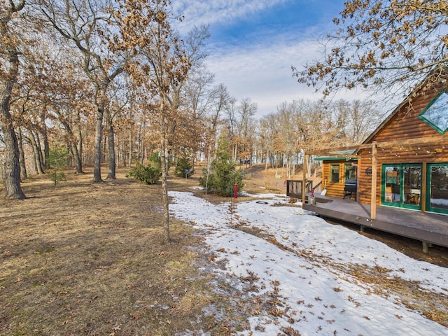 yard layered in snow with a wooden deck