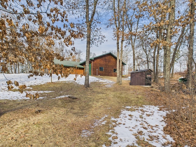 yard layered in snow with an outbuilding