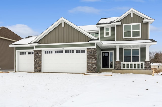 craftsman house with board and batten siding, covered porch, and a garage