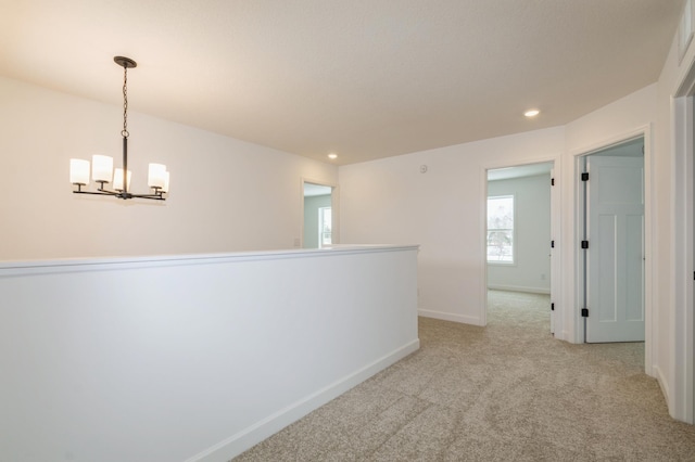 hall with light carpet, baseboards, a chandelier, and recessed lighting