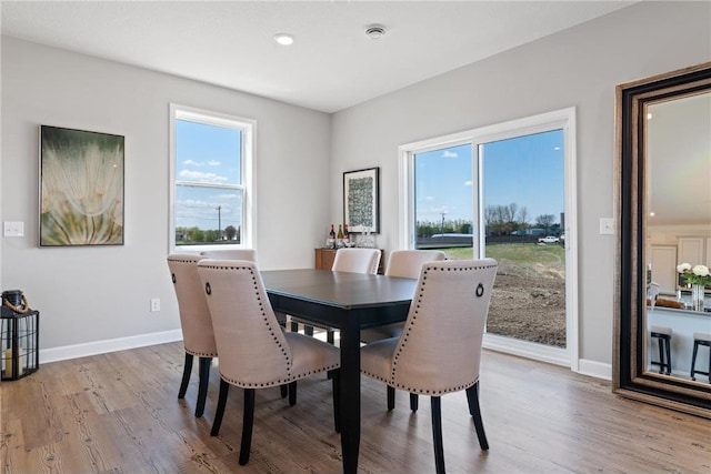 dining room with light wood-type flooring and baseboards