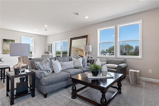 living area featuring a textured ceiling, recessed lighting, light carpet, and baseboards