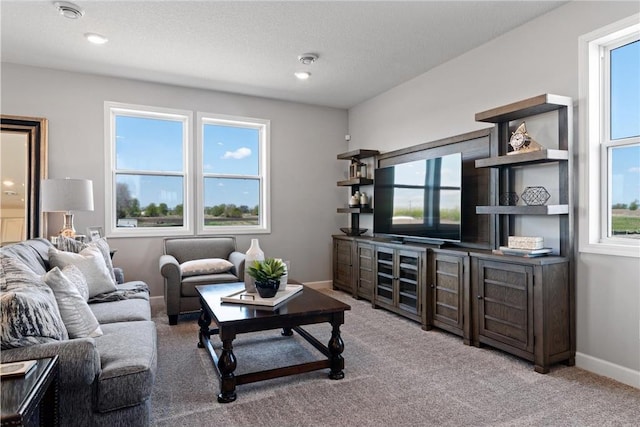 carpeted living area featuring a textured ceiling and baseboards