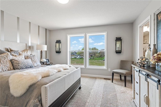 bedroom featuring light carpet, a textured ceiling, and baseboards