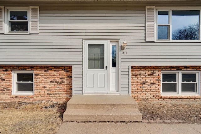 entrance to property featuring brick siding