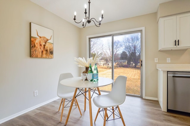 dining room featuring light wood finished floors, baseboards, and a chandelier