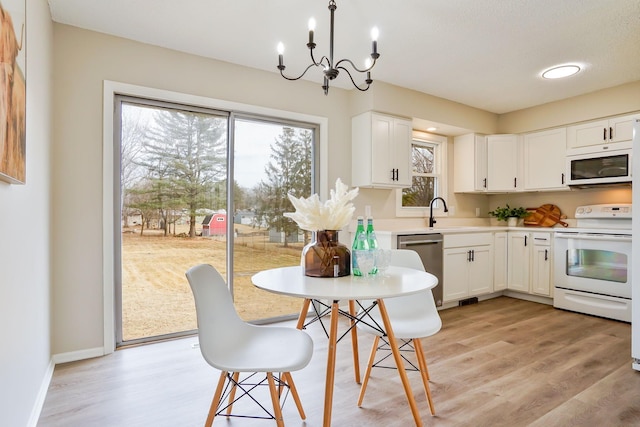 kitchen featuring light wood-type flooring, white appliances, and white cabinetry