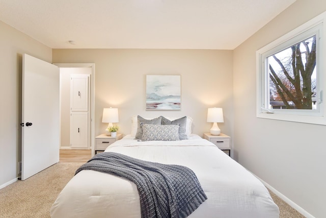 bedroom with light carpet and baseboards