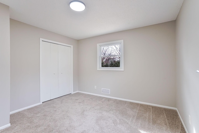 unfurnished bedroom featuring carpet, a closet, and baseboards