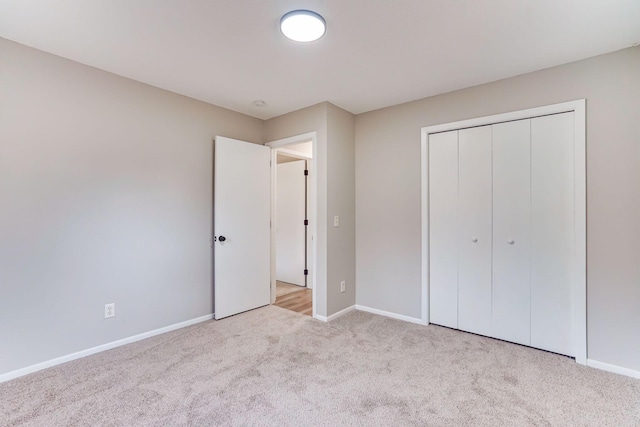 unfurnished bedroom featuring carpet floors, a closet, and baseboards