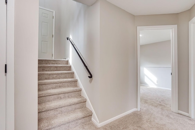 stairway featuring carpet and baseboards