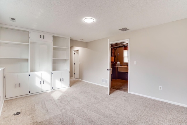 unfurnished bedroom featuring light colored carpet, visible vents, and baseboards