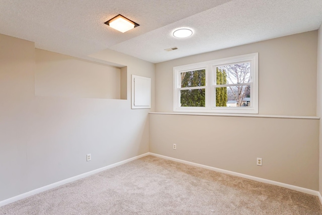 empty room with carpet, visible vents, and baseboards