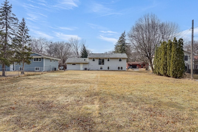 back of house with fence and a lawn