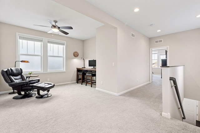 living area featuring carpet floors, recessed lighting, visible vents, and an upstairs landing