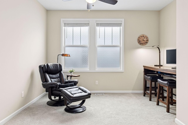 living area featuring ceiling fan, carpet floors, and baseboards