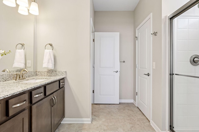 full bath featuring baseboards, a shower stall, and vanity