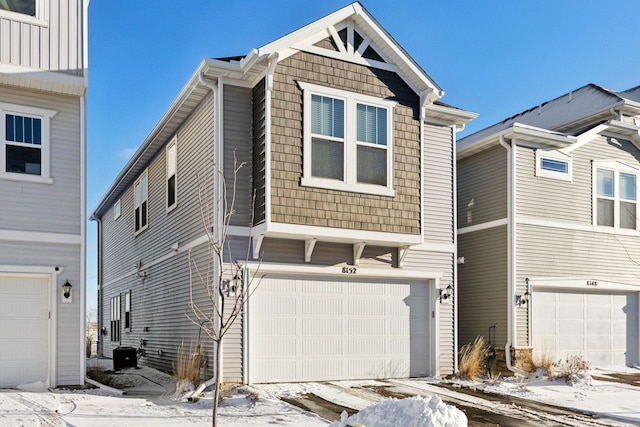 view of front of home with central air condition unit and a garage