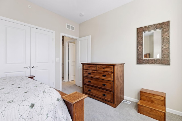 bedroom featuring a closet, visible vents, and light carpet