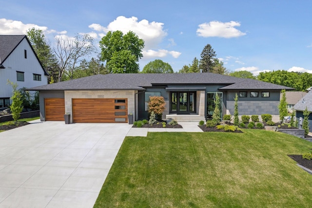 view of front of home featuring a garage, driveway, a front lawn, and roof with shingles