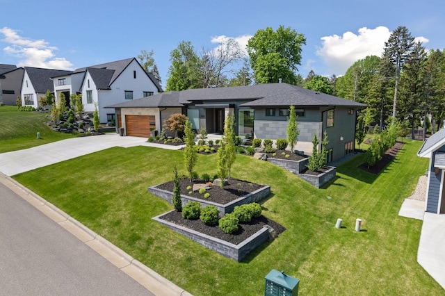 view of front of property with a front yard, concrete driveway, a garden, and an attached garage