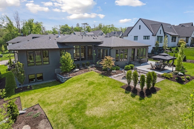 back of house featuring brick siding, a yard, a gazebo, a sunroom, and a patio area