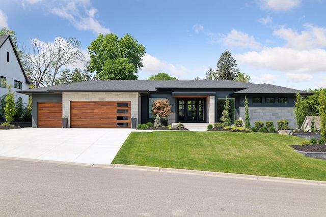 view of front facade featuring a garage, concrete driveway, a front lawn, and roof with shingles