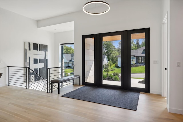 entryway with baseboards, wood finished floors, and french doors