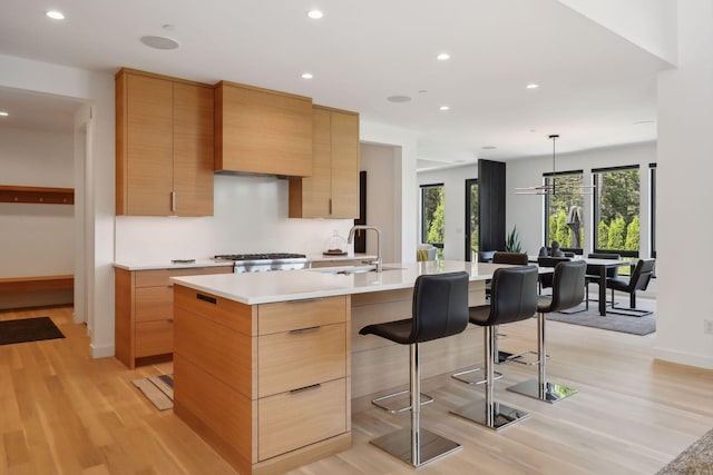 kitchen with light countertops, light wood finished floors, modern cabinets, and recessed lighting