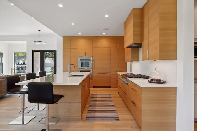 kitchen with modern cabinets, a kitchen breakfast bar, and a sink