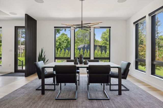 dining space with a chandelier, baseboards, and wood finished floors