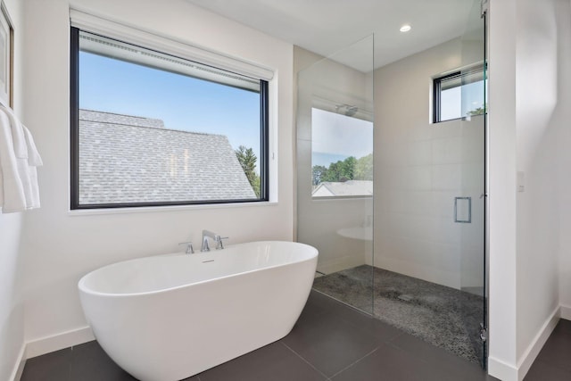 bathroom featuring a stall shower, a soaking tub, baseboards, and recessed lighting