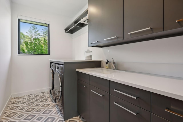 laundry room with baseboards, cabinet space, a sink, and washing machine and clothes dryer