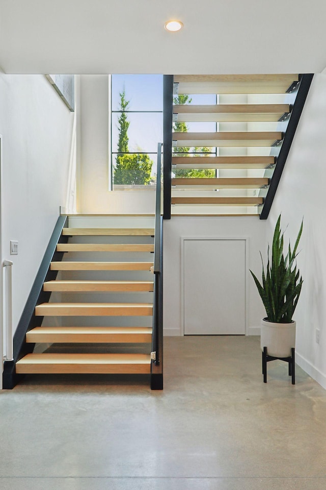 stairway with concrete flooring and recessed lighting