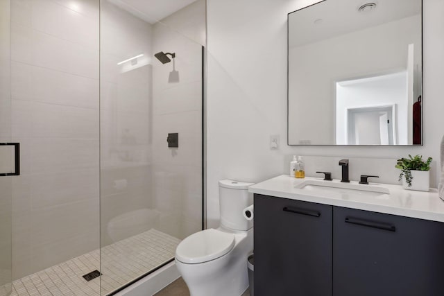 bathroom featuring vanity, a shower stall, and toilet